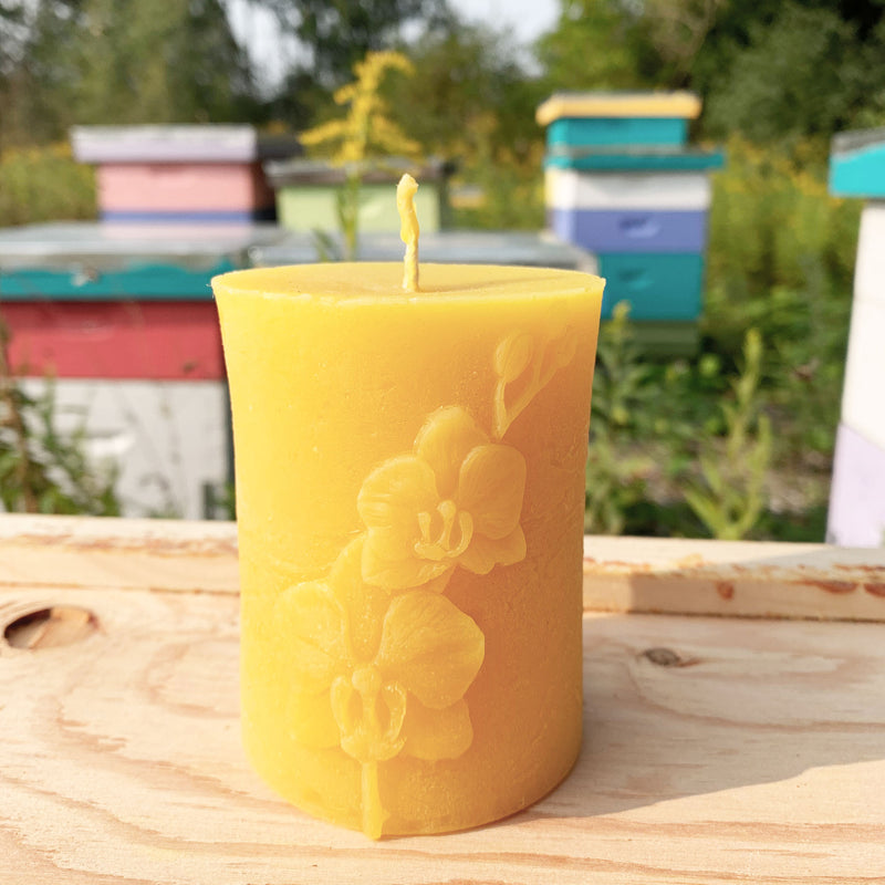 Circular beeswax candle with orchid pattern